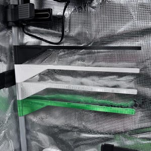 Op de afbeelding: Een close-up van verschillende veelkleurige, rechthoekige planken. De planken zijn zwart, wit, helder en groen. De tekst "Plant Technology" is zichtbaar op de bovenste plank. De planken zijn gemonteerd op een zilveren, reflecterende ondergrond.