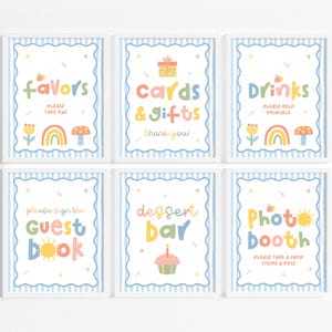 May include: Six framed signs with white borders and blue striped backgrounds. Each sign has colorful text and illustrations. The signs read "Favors," "Cards & Gifts," "Drinks," "Guest Book," "Dessert Bar," and "Photo Booth."