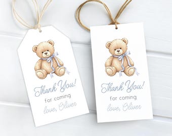 May include: Two white gift tags with a watercolor illustration of a teddy bear wearing a blue ribbon. The tags have the text "Thank You!" and "for coming love, Oliver" in blue script, with twine attached.