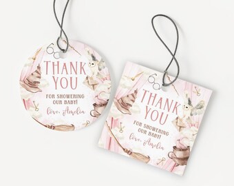 May include: Two baby shower thank you tags. One is round, the other square. Both have a pink background with illustrations of a sorting hat, owl, broom, and keys. Text reads "Thank You" and "For Showering Our Baby!" with the name "Amelia".