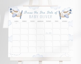 May include: A white calendar with the text "Guess the Due Date of BABY OLIVER" and a calendar grid. The design includes watercolor airplanes and clouds in shades of blue. The calendar is displayed on a white easel.