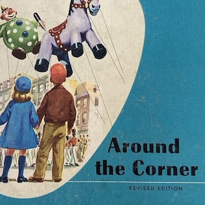 Op de afbeelding: Vintage kinderboek getiteld "Around the Corner" met een blauwe kaft. De kaft bevat illustraties van een ezelpop, een clownpop en twee kinderen. De tekst "The Ginn Basic Readers" staat bovenaan.