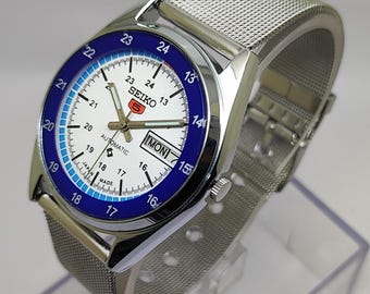 Reloj automático vintage Seiko 5: esfera blanca, bisel azul, correa de malla