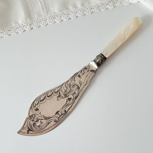 May include: A set of three ceramic mugs with a speckled, matte finish in cream, light grey, and dark grey. Each mug has a simple, minimalist design and a rounded handle.