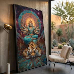 Op de afbeelding: Grote ingelijste kunstdruk met een veelarmige godheid in turkooizen gewaden, zittend op een tijger. Het kunstwerk heeft een hemelse achtergrond met een cirkelvormig ontwerp en is zwart omlijst. De print wordt tentoongesteld naast een raam met uitzicht op een woestijnlandschap.