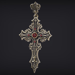 May include: A metallic cross pendant featuring intricate scrollwork and filigree detailing. The design includes a central round red gemstone surrounded by four smaller red gemstones set within the dark, textured metal surface of the cross.