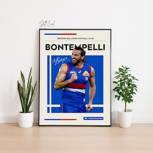May include: A framed poster featuring a man in a blue, red, and white sports uniform. The poster includes the text "BONTEMPELLI" and "WESTERN BULLDOGS FOOTBALL CLUB", along with a signature. The background is a light beige colour.