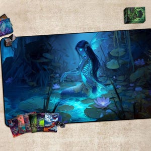 May include: A large rectangular gaming mousepad featuring a fantasy illustration of a glowing blue mermaid in a swamp. The pad is surrounded by other gaming accessories, including card decks and dice. The color palette is primarily blues and greens.
