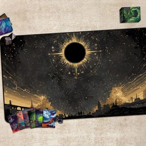 May include: A black and gold gaming mat featuring a celestial design with a central sunburst and a starry sky. The mat includes a cityscape silhouette at the bottom. Several card decks and dice are placed around the mat.