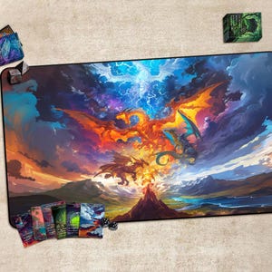 May include: A large, rectangular gaming mat featuring a vibrant fantasy scene with dragons, a volcano, and a dramatic sky. The mat is surrounded by card decks and dice. The artwork is rich in color, with fiery oranges, blues, and purples dominating the scene.