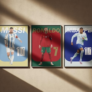 Può includere: Tre poster rettangolari da parete con calciatori. Il poster a sinistra mostra Messi in maglia bianca e blu con il testo MESSI e 10. Il poster centrale mostra Ronaldo in rosso con RONALDO e 7. Il poster a destra mostra Mbappe in bianco con MBAPPE e 10.
