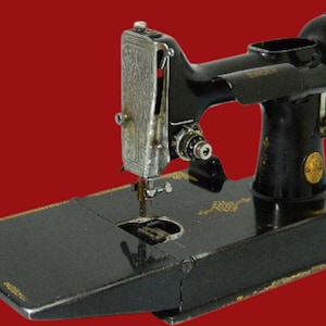 Könnte beinhalten: Vintage schwarze Singer Nähmaschine mit goldenen Akzenten. Die Maschine hat einen silbernen Nadelhalter und eine schwarze Basis mit goldenen Buchstaben. Der Hintergrund ist rot.