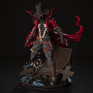 Puede incluir: Figura detallada de un personaje con sombrero negro y capa roja, sosteniendo un arma. La figura tiene un emblema blanco en el pecho y está de pie cerca de una lápida y una valla rota. La figura lleva pantalones y botas negras.