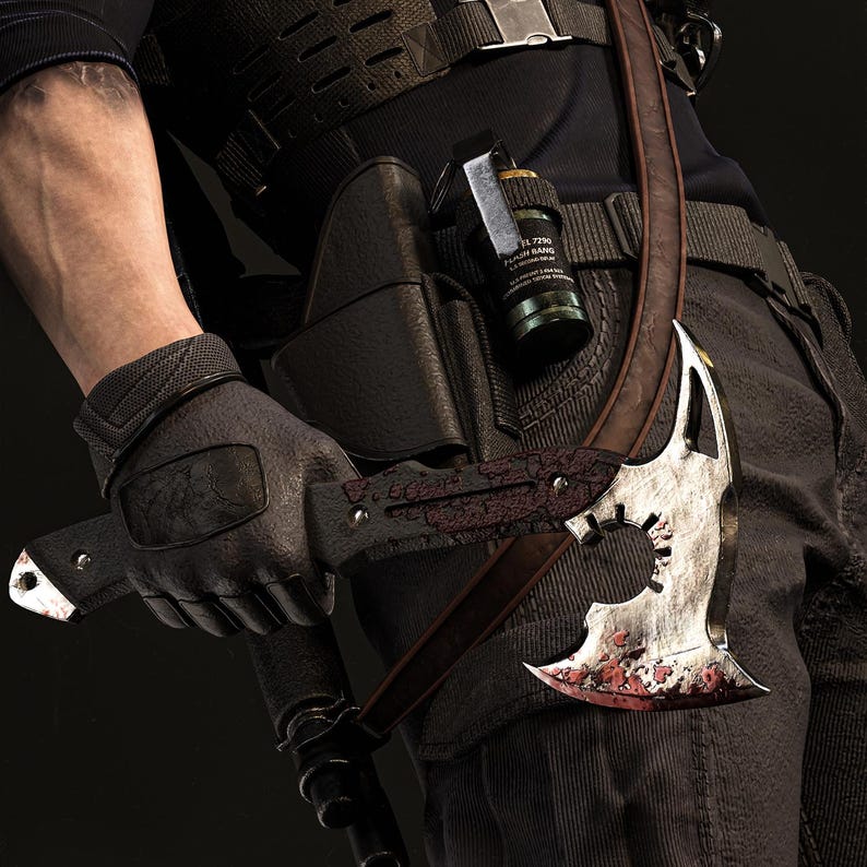 May include: A tactical axe with a silver blade and a brown handle is held by a person wearing black gloves. The axe is strapped to the person's body with a brown strap. A black holster and a grenade are also visible.