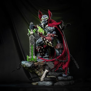 Puede incluir: Figura de acción detallada de Spawn, un personaje de cómic, de pie sobre una base de piedra. La figura lleva una capa roja, una armadura con púas y sostiene una espada verde brillante. La figura tiene una cara de calavera y está en una pose dinámica.
