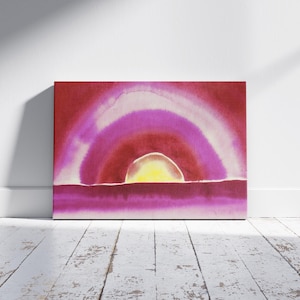 May include: A rectangular canvas art piece featuring an abstract watercolor design. The artwork showcases a sunset scene with a yellow sun, a pink and white arch, and a red and pink horizon. The painting is displayed against a white wall.