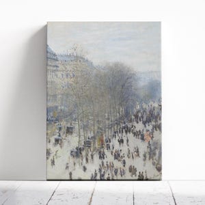 May include: An impressionistic painting of a busy city street. The artwork shows numerous figures, trees, and buildings, in muted tones of grey, white, and brown. The canvas is rectangular and mounted on a wooden frame.