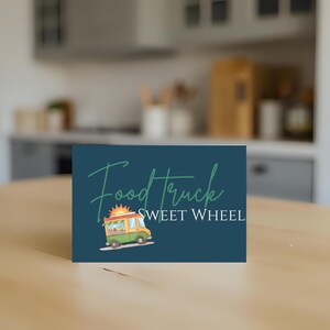 May include: A navy blue card with the words "Food Truck" in a script font and "SWEET WHEEL" in a sans-serif font. A cartoon food truck with a sun on top is also featured. The card is on a wooden surface.