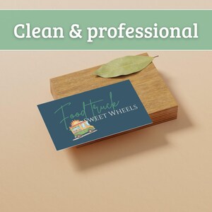 May include: A business card with the text "Food Truck Sweet Wheels" and a food truck illustration, resting on a wooden block. A green leaf sits on top of the block. The words "Clean & professional" are at the top.