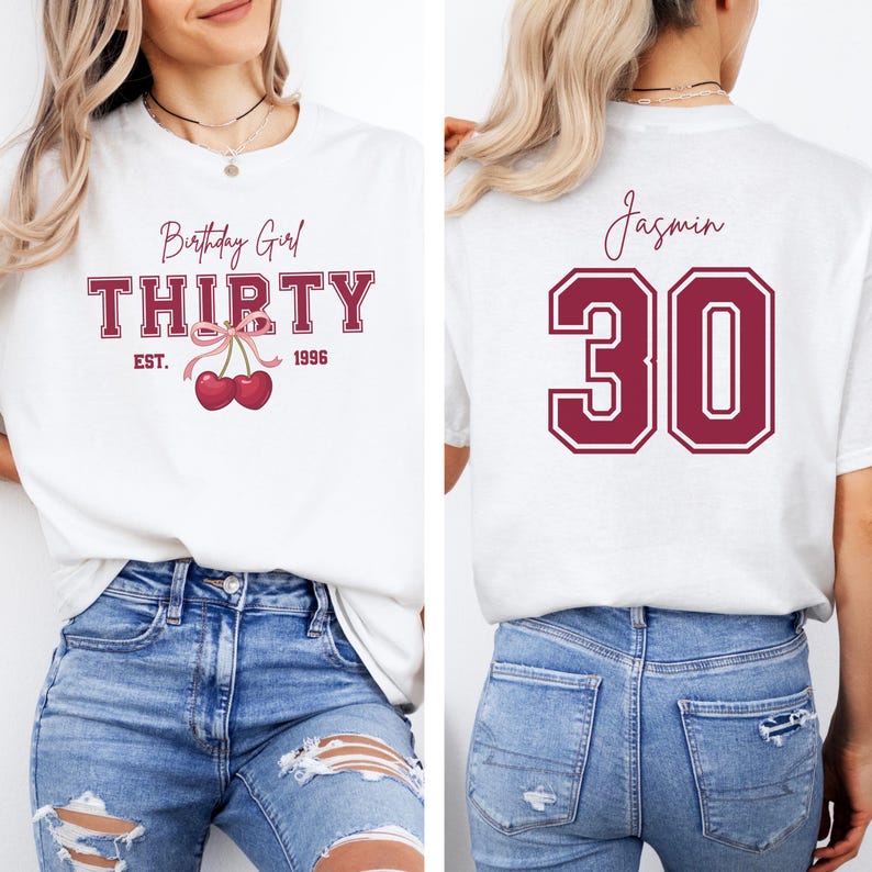 May include: A white t-shirt featuring a front graphic with the text Birthday Girl THIRTY EST. 1996 and a pair of red cherries with a pink bow. The back of the shirt displays the name Jasmin above the large maroon number 30 in a collegiate font.