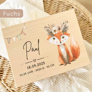 May include: Wooden plaque with a cartoon fox illustration wearing a floral crown. The plaque includes the name "Paul", date, time, and weight, and measures 52 cm in length. The word "Fuchs" is in the upper left corner.