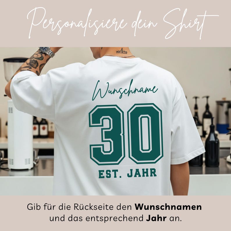 Op de afbeelding: Wit T-shirt met een groen en wit nummer 30 ontwerp op de achterkant. De tekst "Wunschname" staat boven het nummer en "EST. JAHR" eronder. Het shirt heeft ook de tekst "Personalisiere dein Shirt" bovenaan.