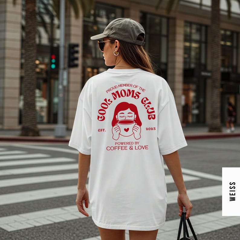 May include: White t-shirt with a red graphic on the back that reads "Cool Moms Club" with a drawing of a woman holding a coffee cup. The text "Powered by Coffee & Love" is below the graphic.