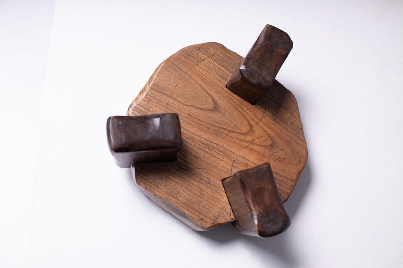 Puede incluir: Escultura de madera hecha a mano con una base irregular de color marr&oacute;n claro y tres bloques rectangulares de color marr&oacute;n oscuro. La escultura es de madera y tiene un acabado natural. La base mide unos 20 cm de di&aacute;metro.