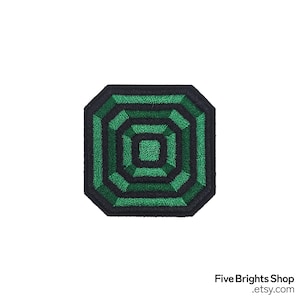 May include: A green and black embroidered patch with a geometric design. The patch features a series of concentric octagons in varying shades of green, outlined in black. The patch is a square shape with rounded corners. The text "Five Brights Shop .etsy.com" is at the bottom.