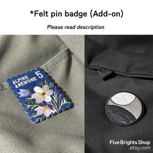 May include: Two felt pin badges are shown. One is a blue rectangle with a floral design and the words "ALPINE ANEMONE 5". The other is a circular badge with a landscape design. The text "Five Brights Shop .etsy.com" is also visible.