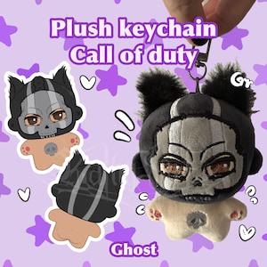 May include: A plush keychain featuring a character with a grey skull mask, brown eyes, and black fur ears. The plush has a tan body with a small grey skull icon on the chest. The text "Plush keychain Call of duty" and "Ghost" is visible.
