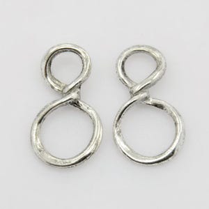May include: A pair of silver infinity symbol earrings. The earrings are made of twisted metal and have a textured finish.