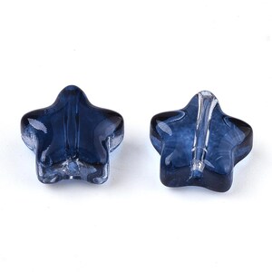 May include: Two blue glass star-shaped beads with a hole in the center for stringing.