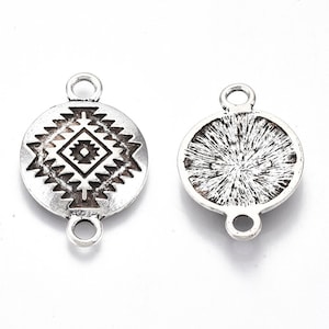 May include: Two silver-toned metal charms with a loop on each side. One charm features a geometric pattern, while the other has a textured surface.