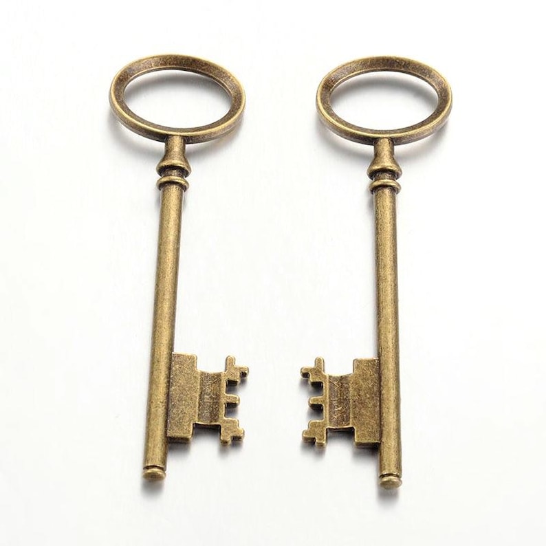 Puede incluir: Dos llaves esqueleto antiguas de color dorado con mirillas ornamentadas y detalles decorativos. Las llaves tienen un aspecto vintage y son perfectas para proyectos de artesan&iacute;a.