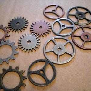 May include: Assortment of metal gears in various sizes and shapes, including round, star-shaped, and with intricate designs. The gears are in shades of silver, copper, and bronze.