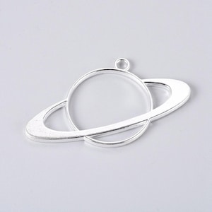 May include: Silver-toned metal pendant shaped like a planet with a ring around it. The pendant is blank and ready to be customized.