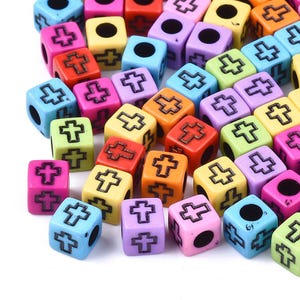 May include: Assortment of colorful plastic cube beads with a cross design. The beads are in various colors, including red, yellow, blue, green, and purple.