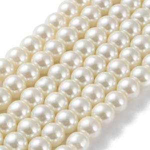 May include: Close-up of multiple strands of creamy white, round pearls. The pearls are arranged in diagonal rows, showcasing their smooth, lustrous surface. The image highlights the consistent size and color of the pearls, suggesting they are uniform in quality.