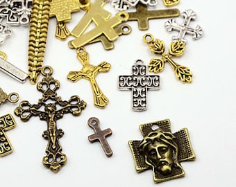 May include: Assortment of antique gold and silver cross charms with intricate designs. The charms feature various styles of crosses, including a cross with a figure of Jesus, a cross with a crown of thorns, and a simple cross.