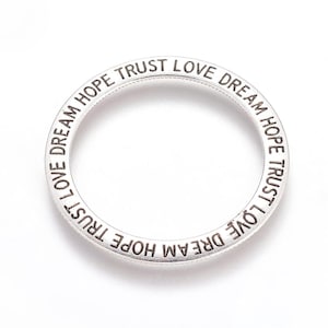 May include: Silver ring with the words "Dream Hope Trust Love" engraved around the band.