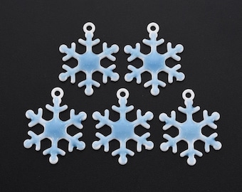 May include: Five white snowflake charms with a light blue glitter finish. The charms have a hole at the top for hanging.
