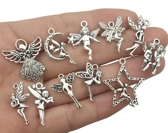 May include: A collection of 12 silver charm pendants featuring various fairy and angel designs. The charms are intricate and detailed, with wings, stars, and other decorative elements.