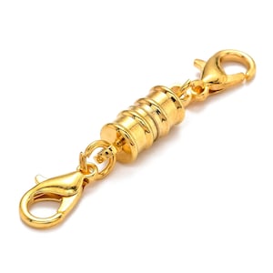 May include: Gold-toned magnetic clasp with two lobster claw clasps. The clasp is designed to connect two pieces of jewelry together.