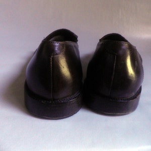 Puede incluir: Un par de mocasines de cuero marr&oacute;n con punta ligeramente puntiaguda. Los zapatos tienen una suela marr&oacute;n oscura y una parte superior de cuero liso.