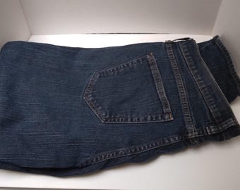 May include: A pair of dark blue denim jeans folded in half. The jeans have a single back pocket.