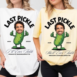 May include: White and yellow t-shirts with a graphic of a smiling face on a pickle giving a thumbs up. The text on the shirts reads "LAST PICKLE" above the pickle graphic, with "AUG. 2025" and "I'll Ever Tickle" and "She'll Ever Tickle" below.