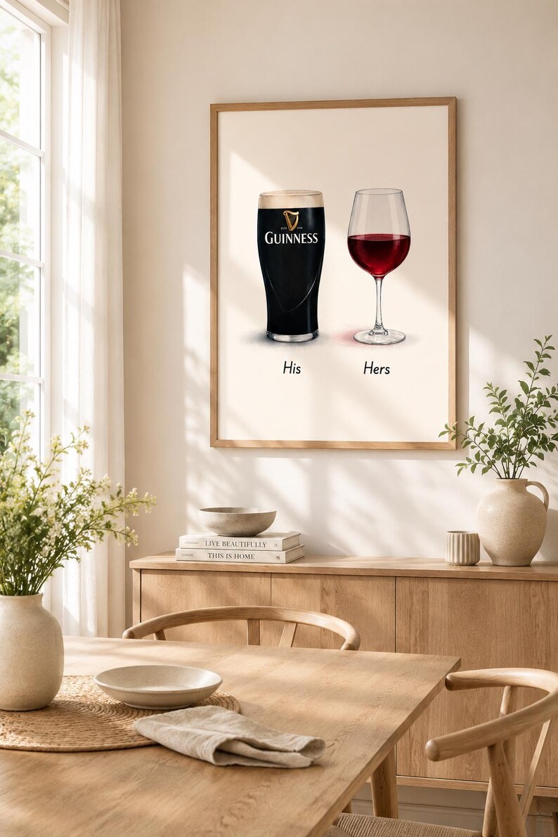 May include: A framed print featuring a pint of Guinness and a glass of red wine, labeled "His" and "Hers." The Guinness glass is black with a white head, and the wine glass is filled with red wine. The print is displayed in a dining room setting.