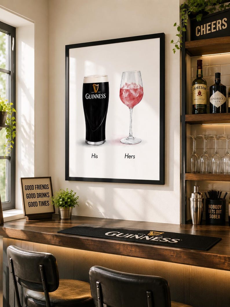 May include: A framed print featuring a pint of Guinness and a glass of pink cocktail, labeled "His" and "Hers." The bar scene includes a Guinness bar mat, a sign that says "Good Friends Good Drinks Good Times," and a shelf with liquor bottles.
