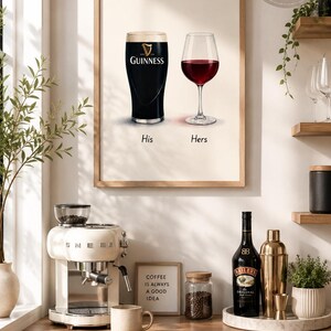May include: A framed print featuring a pint of Guinness and a glass of red wine, labeled "His" and "Hers." The print is displayed above a countertop with a coffee machine, a bottle of Bailey's, and a sign that reads "COFFEE IS ALWAYS A GOOD IDEA."